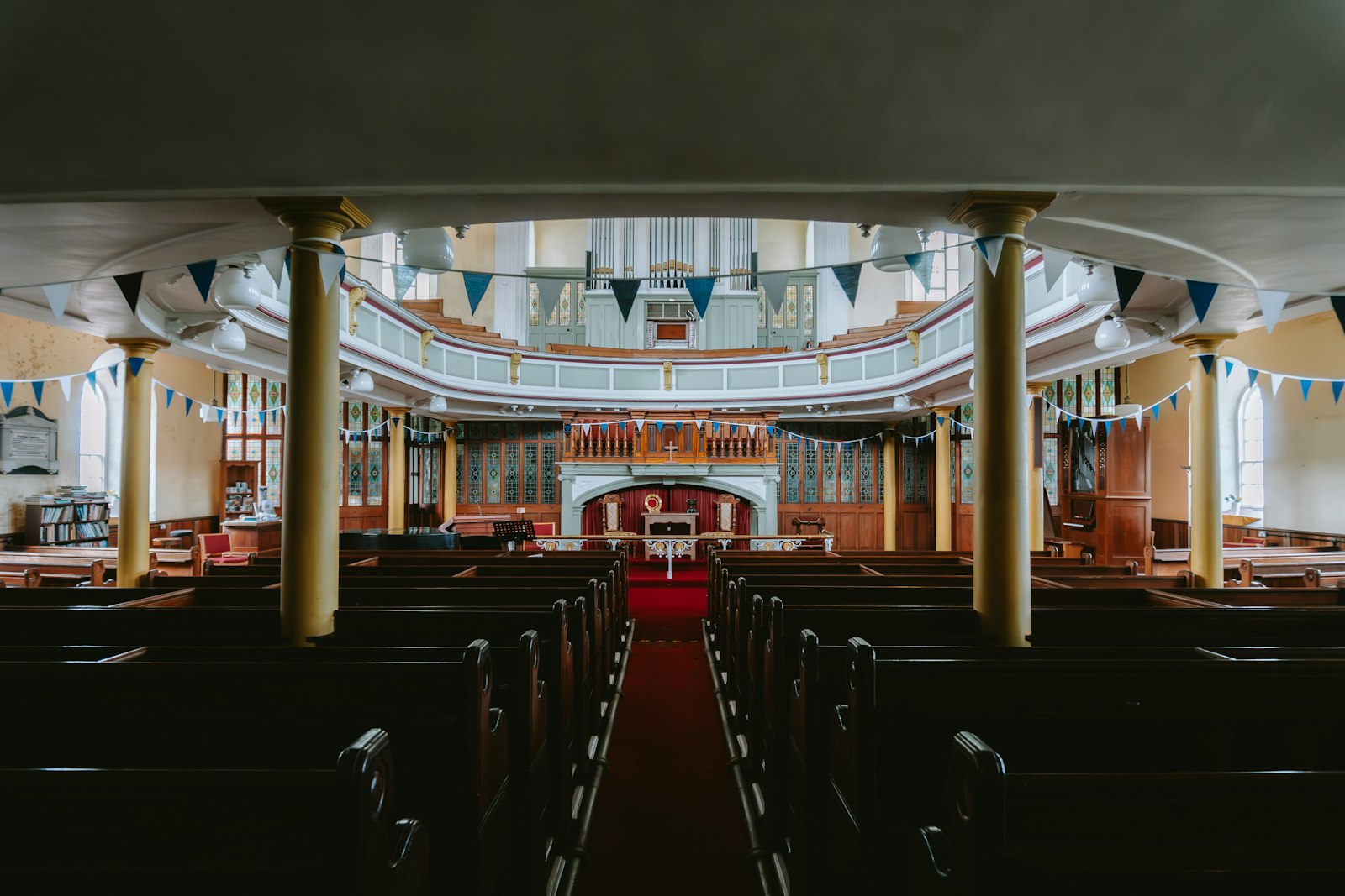 The inside of a church sanctuary with wooden pews and a central aisle